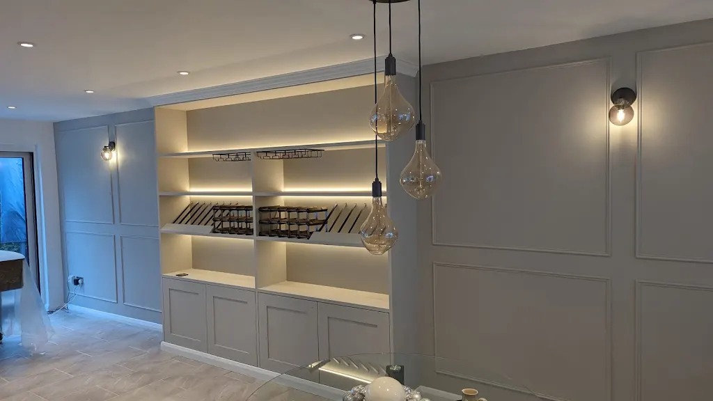 Fitted wine shelf with wall panelling and pendant lights
